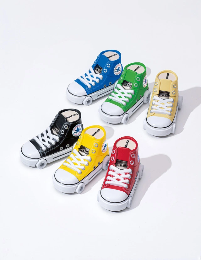 Zestaw zabawek z serii Samochodziki Converse prezentujący sześć modeli w kształcie wysokich trampków w kolorach niebieskim, zielonym, żółtym, czarnym i czerwonym.