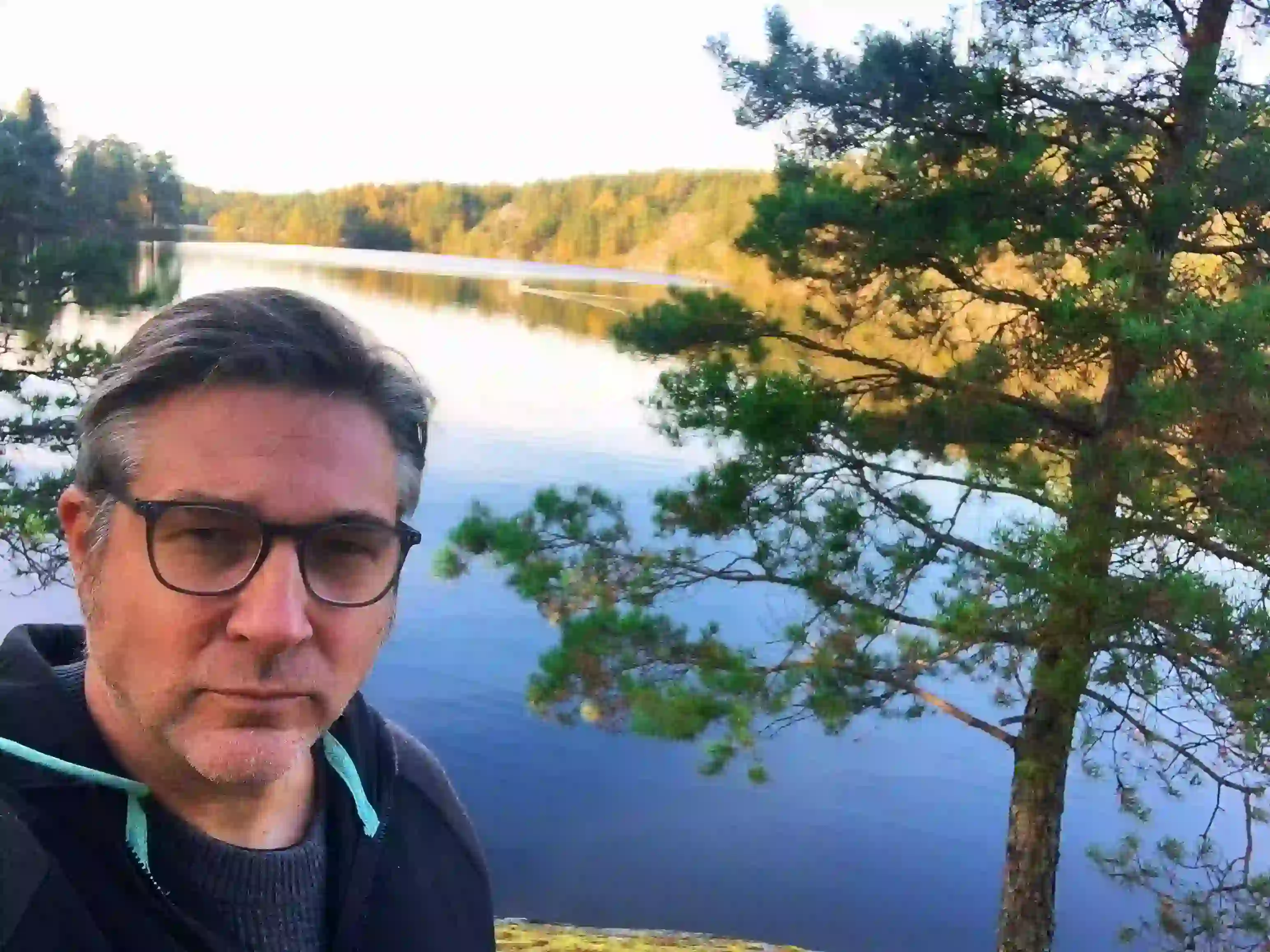 Portret scenarzysty komiksowego Sylvaina Runberga na tle spokojnego jeziora