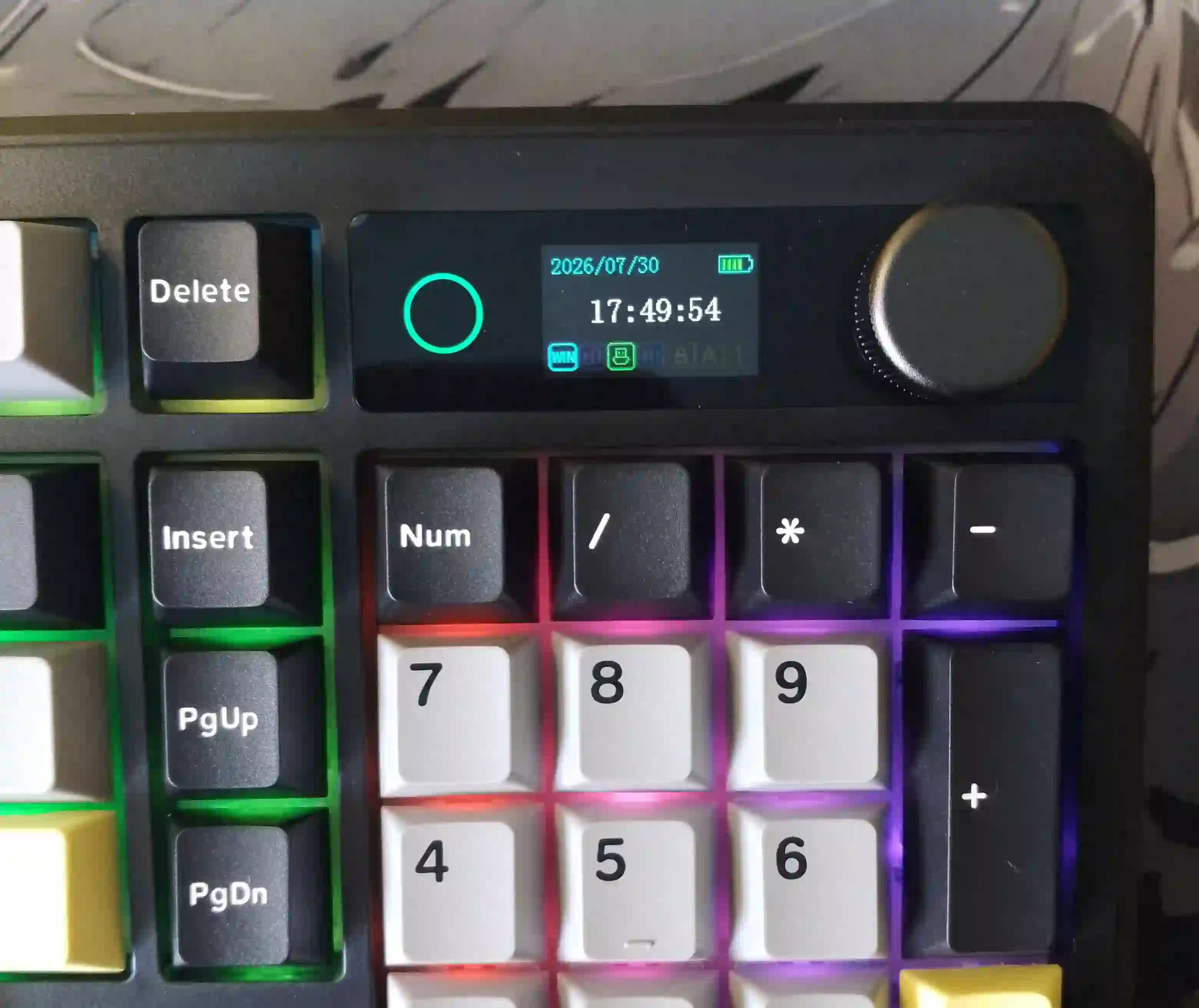 Zbliżenie na wbudowany ekran LCD oraz pokrętło mechanicznej klawiatury Epomaker TH99 Pro z widoczną datą, godziną i stanem baterii.