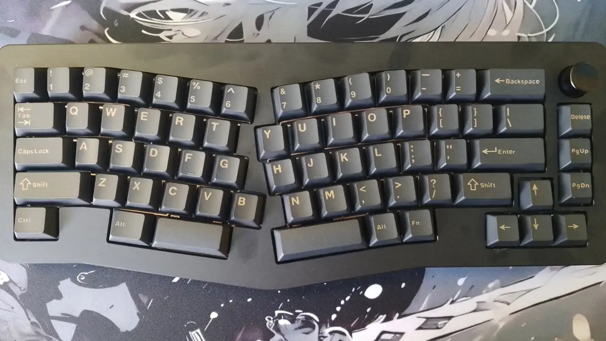 Widok z góry na czarną mechaniczną klawiaturę Epomaker Tide Alice o ergonomicznym układzie, spoczywającą na podkładce.
