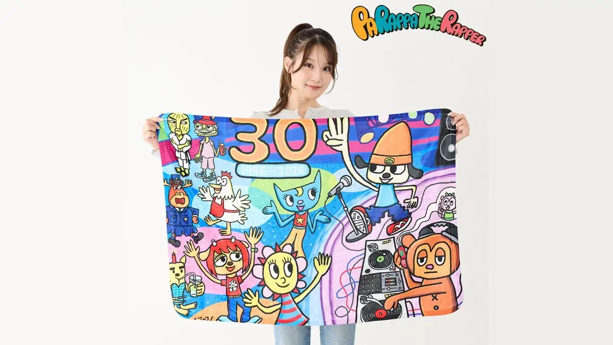 Dziewczyna prezentująca rocznicowy ręcznik z postaciami z PaRappa the Rapper. Kultowa gra rytmiczna z PlayStation świętuje swoje 30-lecie.